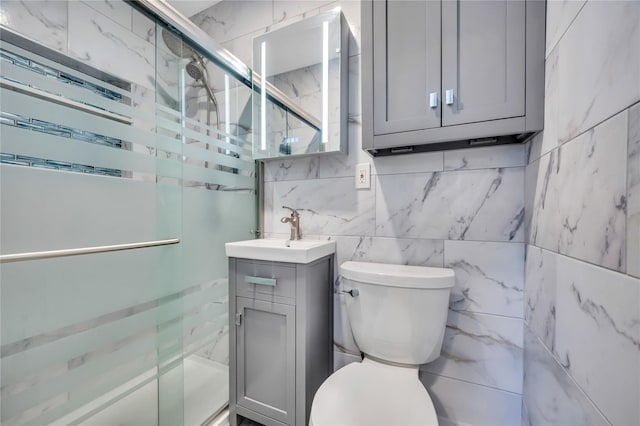 bathroom featuring vanity, a shower stall, and toilet