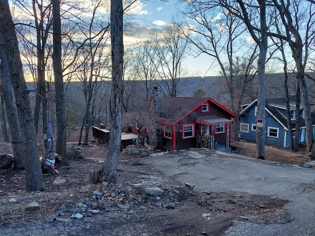 rustic home featuring driveway and a chimney