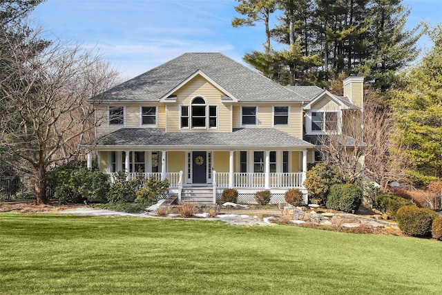 colonial house featuring a chimney, covered porch, roof with shingles, and a front yard