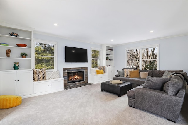 living room with recessed lighting, a fireplace with flush hearth, crown molding, and carpet flooring