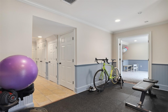 exercise room featuring visible vents, crown molding, and wainscoting