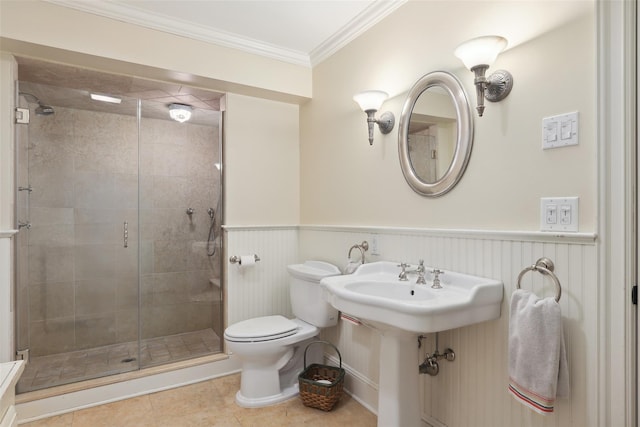 bathroom with a wainscoted wall, crown molding, toilet, a stall shower, and tile patterned floors