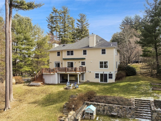 back of property featuring a deck, a yard, stairway, roof with shingles, and a chimney