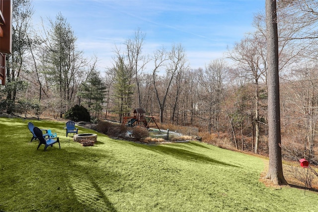 view of yard with an outdoor fire pit and a playground