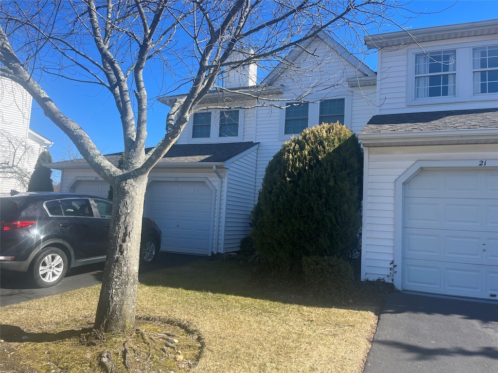 view of home's exterior featuring a garage and roof with shingles