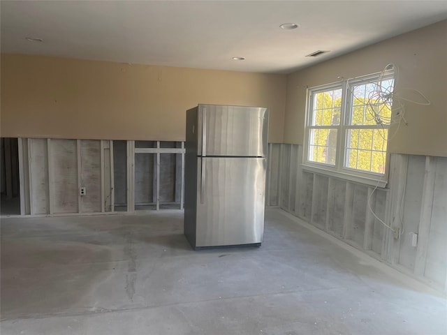 kitchen with freestanding refrigerator and unfinished concrete floors