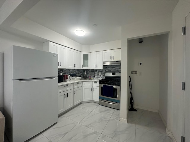 kitchen with stainless steel range with gas cooktop, marble finish floor, backsplash, freestanding refrigerator, and under cabinet range hood