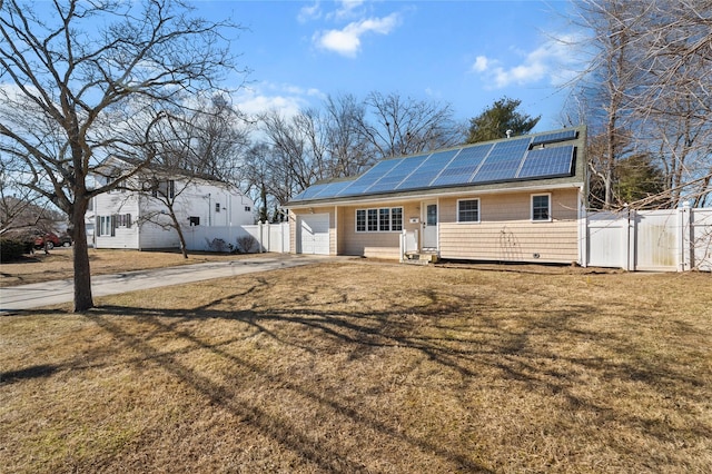 view of front of property with a gate, fence, solar panels, and concrete driveway