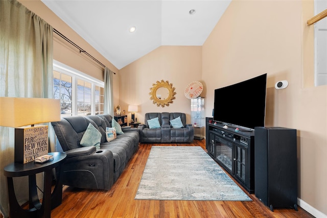 living area featuring lofted ceiling, recessed lighting, baseboards, and wood finished floors