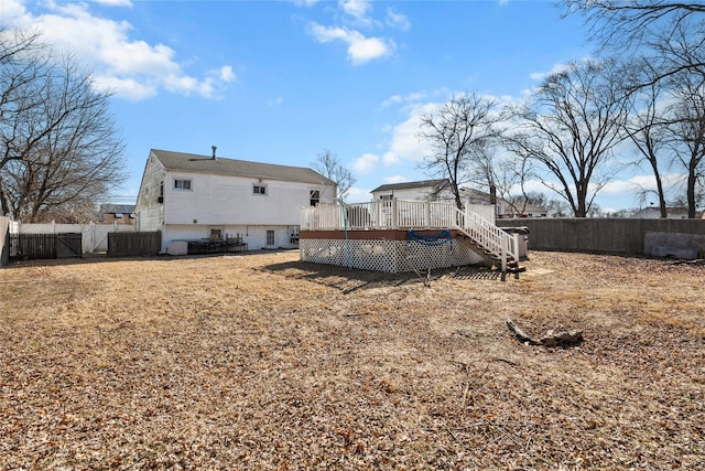 back of property featuring a deck and a fenced backyard