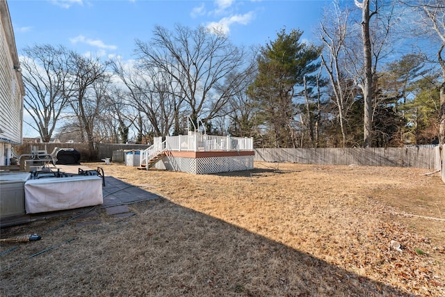 view of yard with a deck, a patio area, a fenced backyard, and stairs