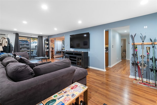 living room with light wood-type flooring, baseboards, and recessed lighting