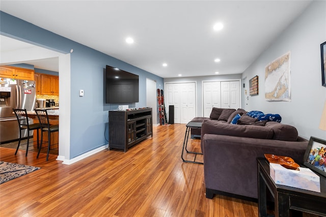 living room featuring light wood-style floors, recessed lighting, and baseboards