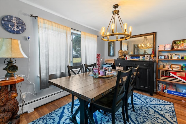 dining room with an inviting chandelier, baseboard heating, and wood finished floors