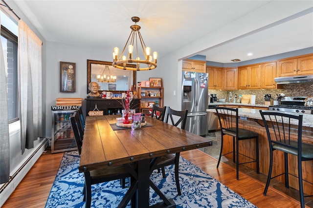 dining area featuring a baseboard radiator, dark wood finished floors, and a wealth of natural light