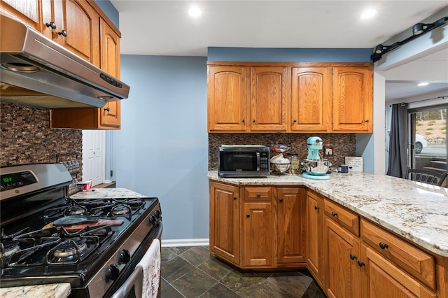 kitchen featuring decorative backsplash, appliances with stainless steel finishes, brown cabinets, light stone counters, and under cabinet range hood