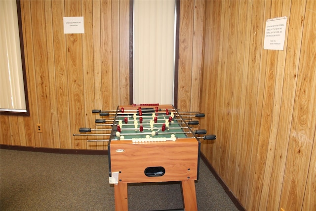 playroom with carpet, wooden walls, and baseboards