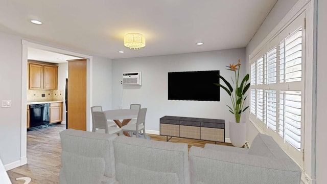 living area with recessed lighting, baseboards, light wood finished floors, and a wall mounted AC