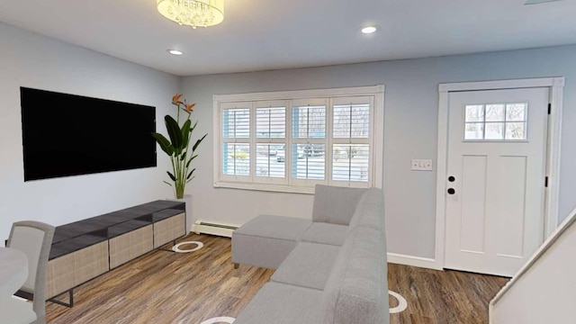 living area with recessed lighting, baseboard heating, and wood finished floors