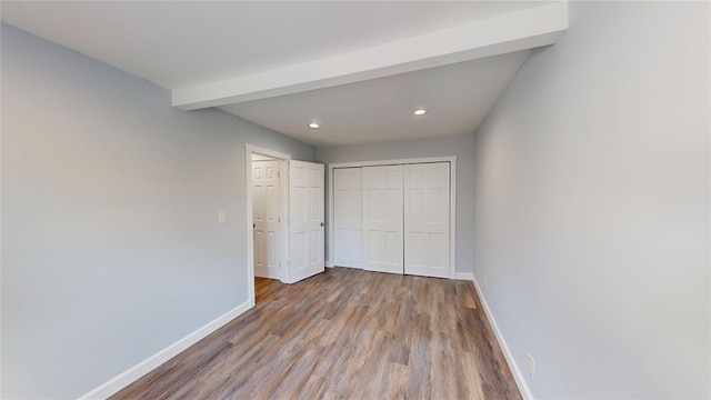 unfurnished bedroom featuring a closet, recessed lighting, wood finished floors, and baseboards