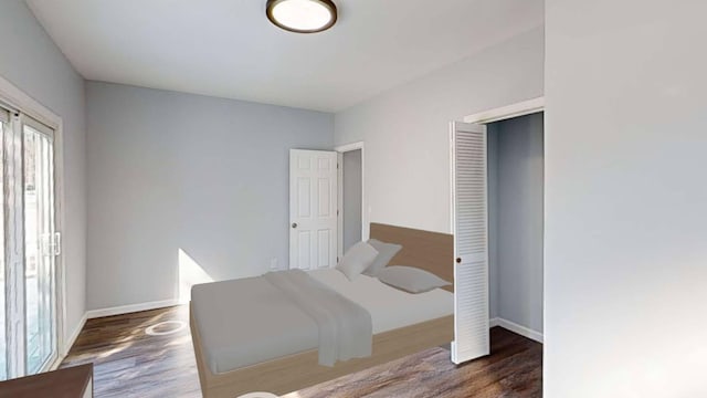 bedroom featuring a closet, wood finished floors, and baseboards