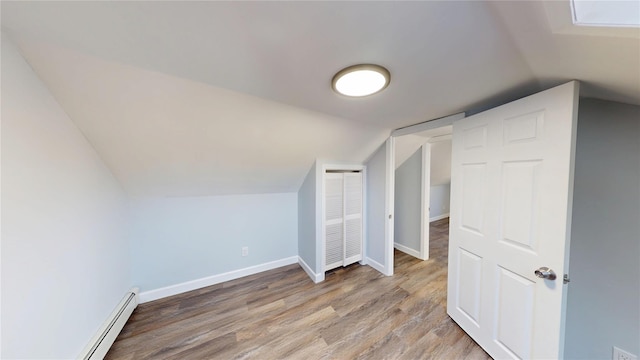 bonus room featuring a baseboard radiator, baseboards, vaulted ceiling, and wood finished floors