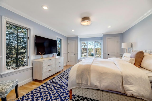 bedroom with recessed lighting, light wood-type flooring, baseboards, and crown molding