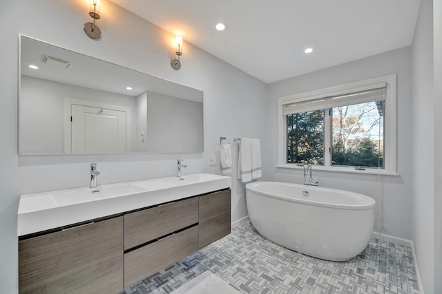 bathroom featuring a sink, visible vents, a soaking tub, and double vanity