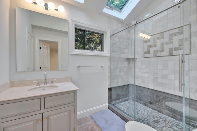 full bathroom with vanity, vaulted ceiling, baseboards, and a stall shower