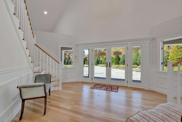 foyer with stairway, visible vents, light wood-style flooring, and french doors