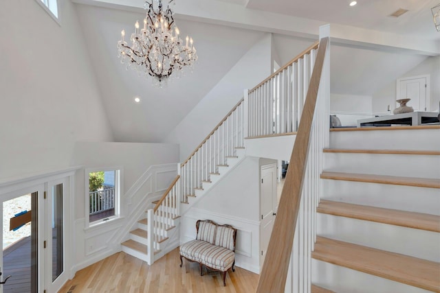 stairs with a wealth of natural light, visible vents, recessed lighting, and wood finished floors