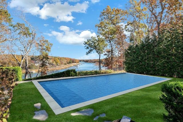 view of swimming pool with a lawn, a water view, and an infinity pool