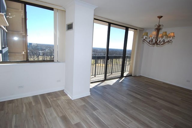 unfurnished dining area featuring visible vents, floor to ceiling windows, baseboards, and wood finished floors