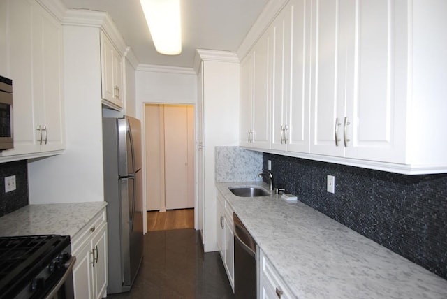 kitchen featuring stainless steel appliances, white cabinets, a sink, and decorative backsplash