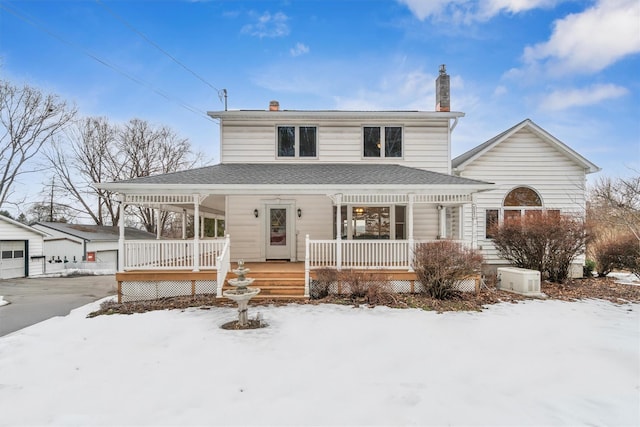 farmhouse inspired home with a porch and an outbuilding