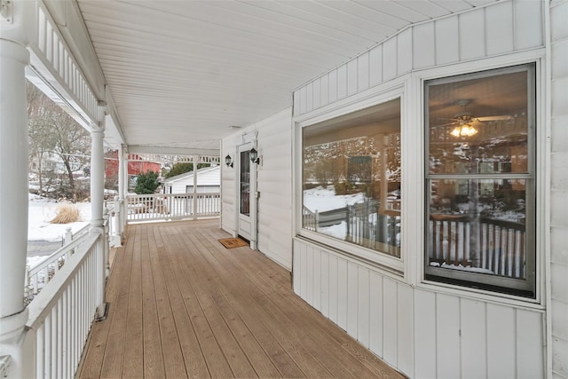 snow covered deck with a porch