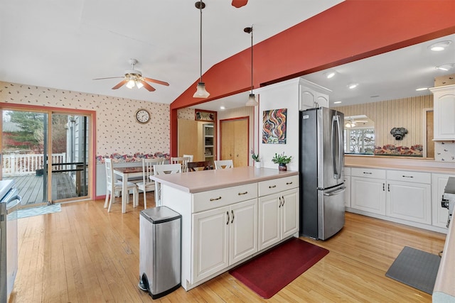 kitchen featuring lofted ceiling, light wood-type flooring, freestanding refrigerator, and wallpapered walls