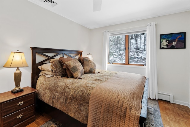 bedroom with ceiling fan, visible vents, baseboard heating, and baseboards