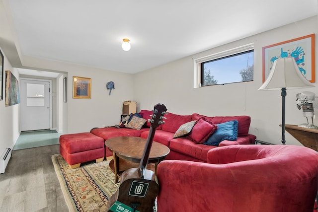 living area featuring a baseboard heating unit and wood finished floors