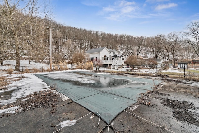 snow covered pool featuring a fenced in pool, a patio area, and fence