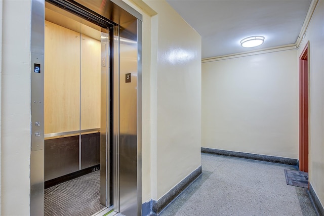 corridor with baseboards, speckled floor, visible vents, and elevator