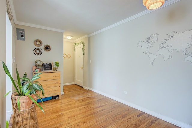 interior space with light wood-style floors, crown molding, and baseboards