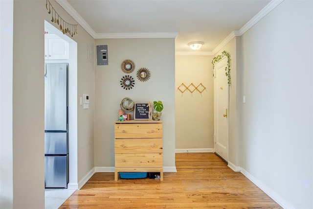 hallway with light wood finished floors, baseboards, and ornamental molding