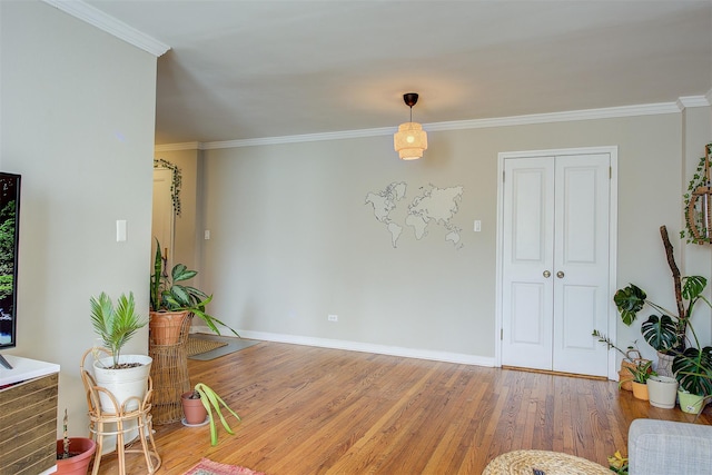 dining room with baseboards, wood finished floors, and crown molding