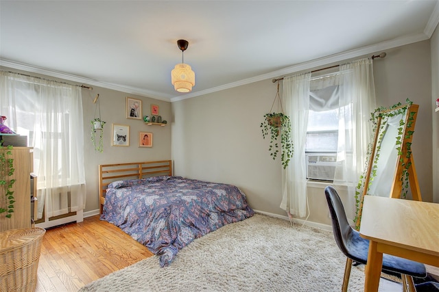 bedroom featuring baseboards, wood finished floors, and crown molding