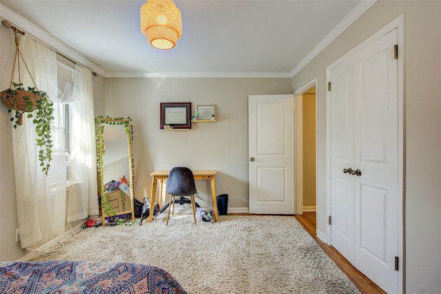 bedroom with baseboards, ornamental molding, and wood finished floors