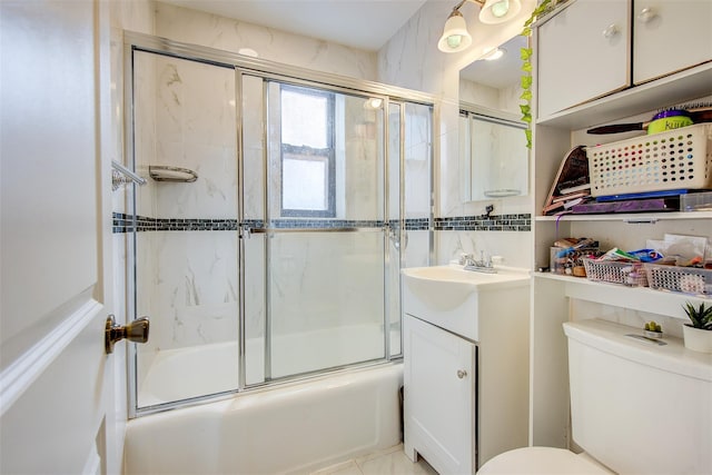 bathroom with shower / bath combination with glass door, vanity, and toilet