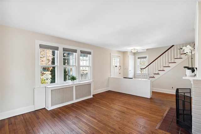 interior space with hardwood / wood-style flooring, stairway, radiator heating unit, and baseboards