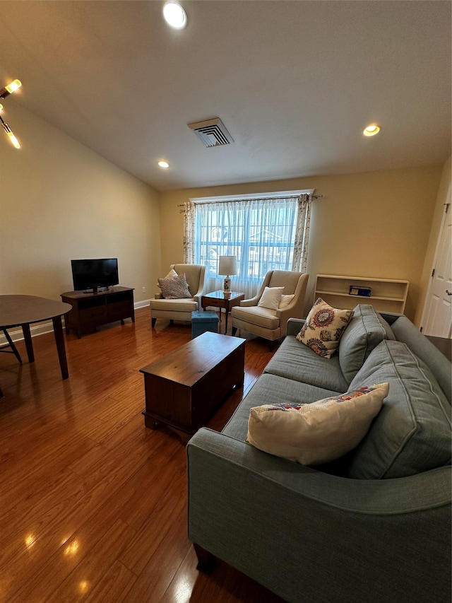 living room with recessed lighting, visible vents, baseboards, and wood finished floors