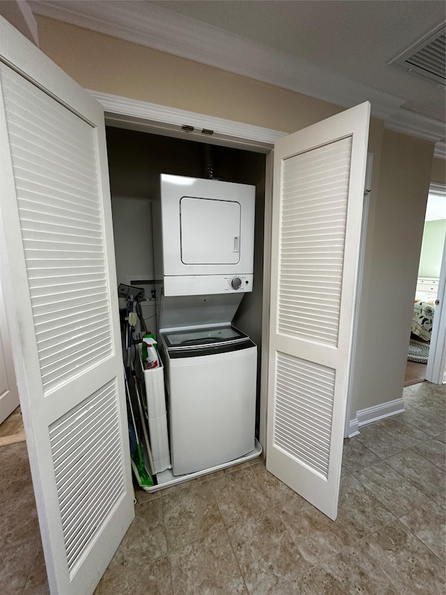 laundry area with laundry area, visible vents, and stacked washer / dryer